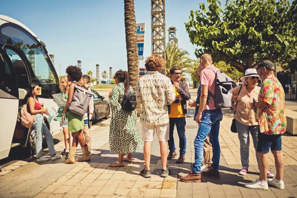 Grupo de viajeros junto a un autocar turístico durante un circuito organizado por Europa