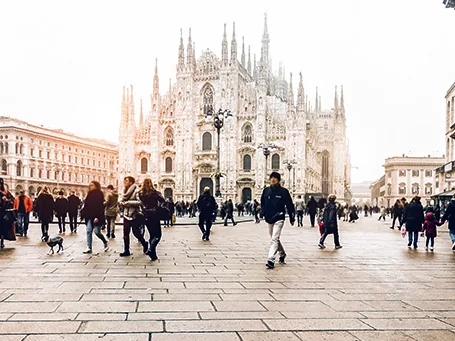 Catedral de Milán en la Piazza del Duomo, Italia, con viajeros recorriendo la plaza.